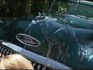 性感的熱的金發女孩在做洗車的比基尼泳裝